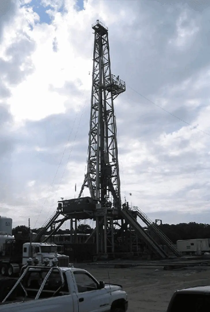 Oil drilling rig under cloudy sky.
